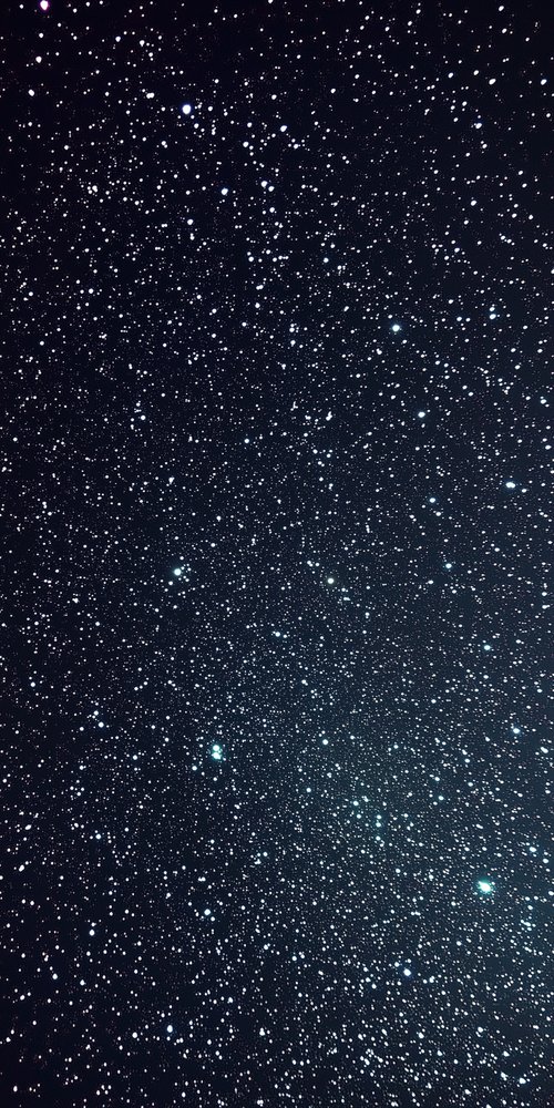 A black sky with a few stars wallpaper