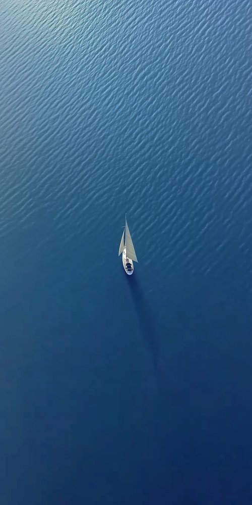 Sailboat on calm blue water wallpaper