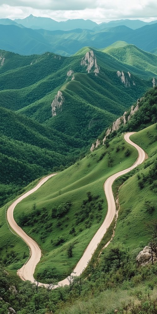 A winding road winding through a lush green valley wallpaper