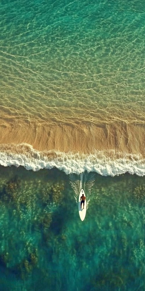 A person on a surfboard in the ocean wallpaper