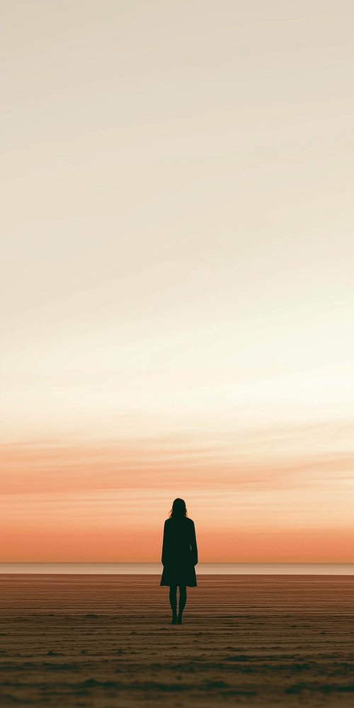 A person walking on a beach at sunset wallpaper